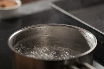 Saicepan with hot boiling water closeup