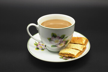 Afternoon coffee and cookies in a white flower mug.Include Clipping Path.