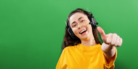 Online courses and learning. Portrait of a young smiling woman wearing headphones, giving a...