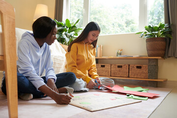 College students cutting colored paper when making placard for anti climate change protest