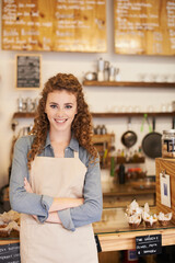 Beautiful barista ready to take your order. An attractive young barista standing at a cafe counter.