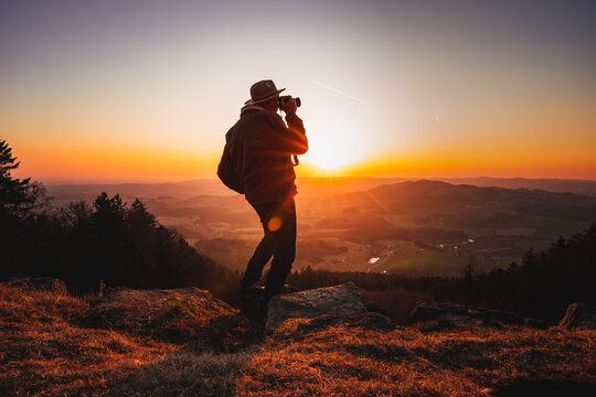 Photographer with camera in sunset taking photos of landscape. Travel Lifestyle hobby concept adventure active vacations outdoor
