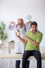 Fototapeta premium Young male patient visiting old male doctor in expensive medicin