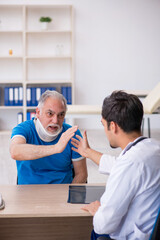 Obraz premium Old neck injured male patient visiting young male doctor