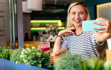 Fototapeta premium Portrait of happy woman smiling and using mobile phone. People technology social network concept