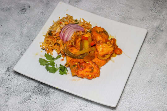 Pieces of spicy Tandoori chicken with Biryani rice , An Indian dish.
