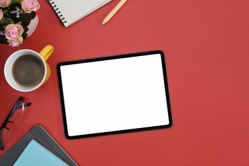 Mockup digital tablet, coffee cup and notebook on red background. Blank display for graphic display montage.