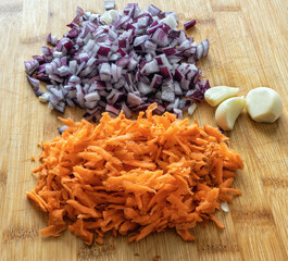 chopped carrots and onions on a cutting board