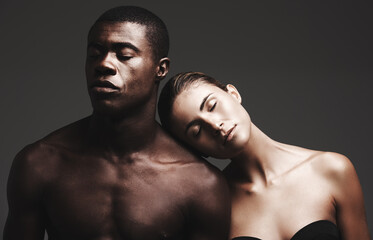 Love your skin. Shot of a beautiful couple posing in a studio - gray background.
