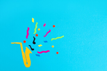 Festival and holiday. A cutted out of felt saxophone on a blue background. Flat lay. International...