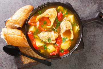 Portuguese Traditional Fishermans Stew Caldeirada De Peixe close-up in a bowl on the wooden board. Horizontal top view from above