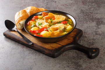 Portuguese Traditional Fishermans Stew Caldeirada De Peixe close-up in a bowl on the wooden board. Horizontal