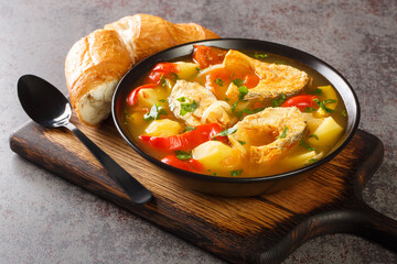 White fish stew with potatoes, peppers, tomatoes and onions close-up in a bowl on the table. horizontal
