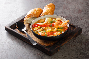 Mediterranean seafood stew with potatoes, peppers, tomatoes and onions close-up in a bowl on the table. horizontal