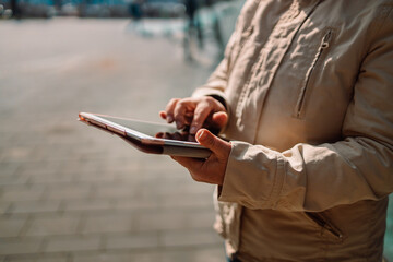 Mature 50s woman using tablet computer near the office building outdooor in city