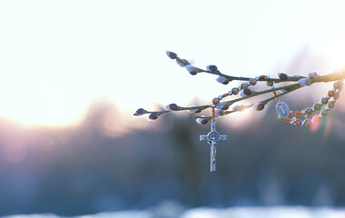 christianity cross and willow branches  against blurred sunny natural background. Easter holiday,...