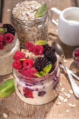 Healthy Homemade Overnight Oats Oatmeal with berry. Portioned Oatmeal with fresh raspberry ans blackberry in a glass jar. Healthy summer breakfast