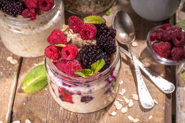 Healthy Homemade Overnight Oats Oatmeal with berry. Portioned Oatmeal with fresh raspberry ans blackberry in a glass jar. Healthy summer breakfast