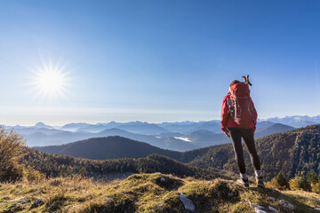 Female hiker admiring Bavarian Prealps at foggy sunrise