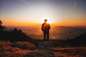 Man standing on the cliff at sunset enjoying the nature view. Bavarian Forest, Germany.