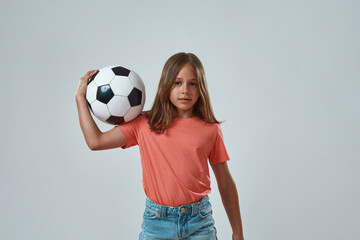 Front view of little girl holding football ball