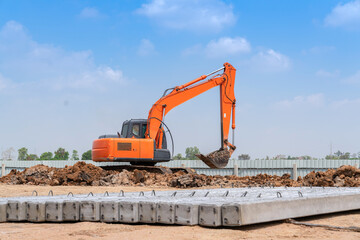 Excavator dig soil for adjust ground and pile of concrete plie