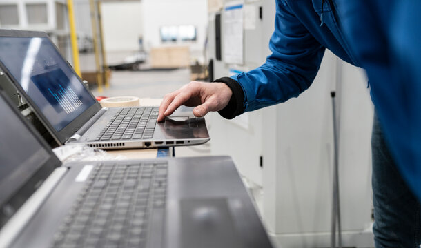 Hand of technician using laptop in factory