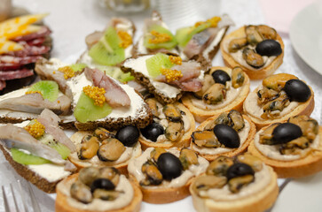 Sandwiches with mussels and olives selective focus. Kiwi and salted fish sandwiches close-up.