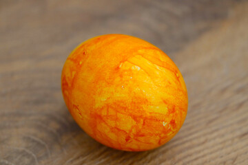 Painted orange egg on the table. Easter egg, spring festival.