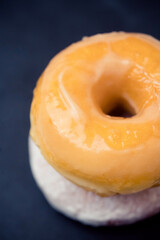 classic glazed donut.Flat lay donut on black plate.sweet doughnut dessert bakery.Unhealthy tasty donut.bakery menu.Bite eat bakery, diet, calories, sugar.