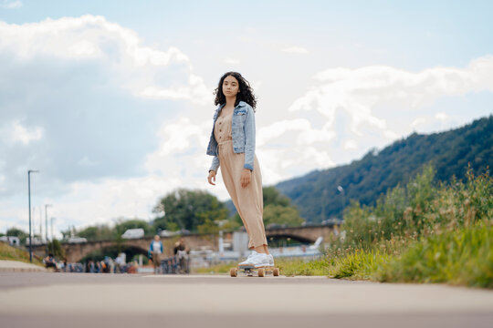 Teenage girl riding skateboard on street