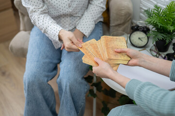 Psychologist uses metaphorical associative cards in a session with a patient. Close-up of female hands.