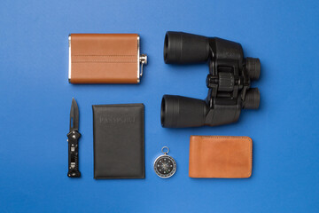 Travel accessories for mountain trip on color background, top view