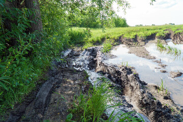 A country road in mud, slush and water after rain. Mud on the forest road