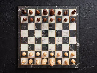 Top view of chessboard with pieces on black background.