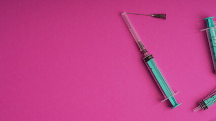 medical disposable syringe for injection in the hospital. plastic syringe on a pink background. the concept of fighting viruses and diseases