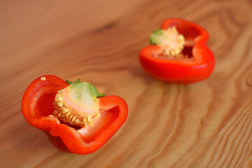 Red pepper on a wooden background sliced in two halfs