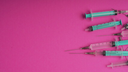 medical disposable syringe for injection in the hospital. plastic syringe on a pink background. the concept of fighting viruses and diseases