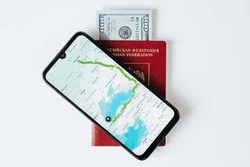 Top view mobile phone with online map application, russian international passport and money, close-up. Trip, journey, travel, emigration, vacation concept