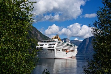 Norwegian fjord landscape with a cruise liner anchored outside the village Flåm in Aurlandsfjorden in Sogn og fjordane fylke in summer.