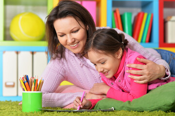 Obraz premium Portrait of little cute girl with mother drawing