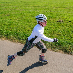 Sportlich unterwegs beim Skaten auf Rollerskates an einem sonnigen Tag