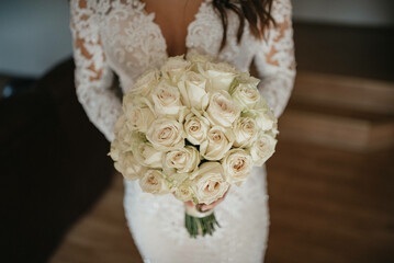 Bride dressed in a white dress holding a wedding bouquet.
