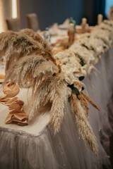 Decoration with fresh flowers, candles, light bulbs, garlands. Vintage style. Table setting for an event party or wedding reception. Event decorations.