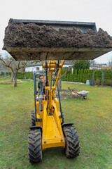 Erde bewegen im eigenen Garten mit einem Mietbagger