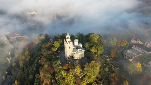 Aerial foggy sunrise view of Tsarevets Fortress in Veliko Tarnovo in a beautiful autumn  day