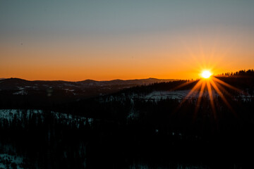 Bright sun before sunset among the mountains.