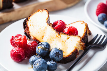 Portion of homemade San Sebastian burnt cheesecake with berries for breakfast.