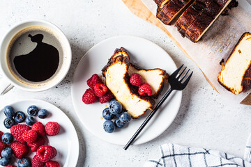 Obraz premium Portion of homemade San Sebastian burnt cheesecake with berries for breakfast.
