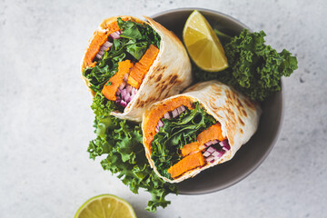 Vegan burrito wrap with sweet potato, kale and onion. Vegetarian food concept.